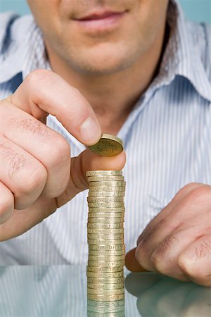 picture of a man counting coins - Man with stack of pounds Stock Photo - Premium Royalty-Free, Code: 614-01870067