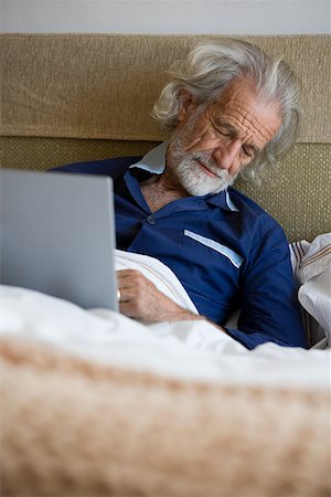 Man in bed with laptop Stock Photo - Premium Royalty-Free, Code: 614-02050048