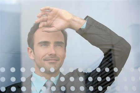 Businessman looking through window Stock Photo - Premium Royalty-Free, Code: 614-02050092