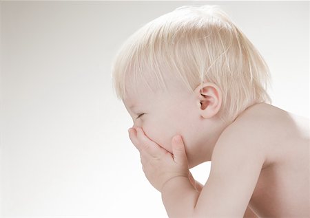 sneezing child - A baby boy covering his face Stock Photo - Premium Royalty-Free, Code: 614-02050210