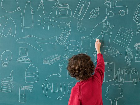 drawing on chalkboard - Boy drawing on a blackboard Stock Photo - Premium Royalty-Free, Code: 614-02050322