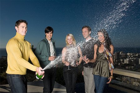 rooftop party - Man spraying champagne Stock Photo - Premium Royalty-Free, Code: 614-02050432