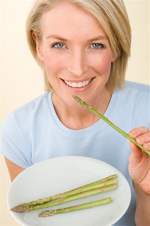 A woman holding a plate of asparagus Stock Photo - Premium Royalty-Free, Code: 614-02050697