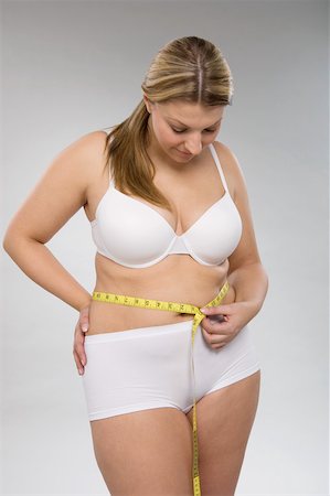 A woman measuring her waist Stock Photo - Premium Royalty-Free, Code: 614-02050766