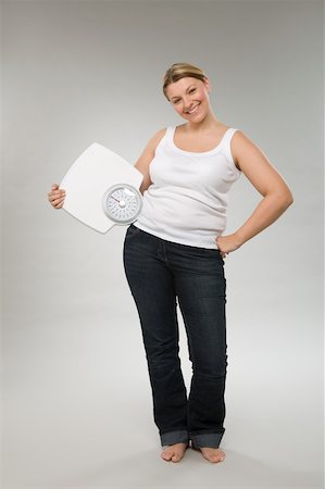A woman holding weight scales Stock Photo - Premium Royalty-Free, Code: 614-02050770