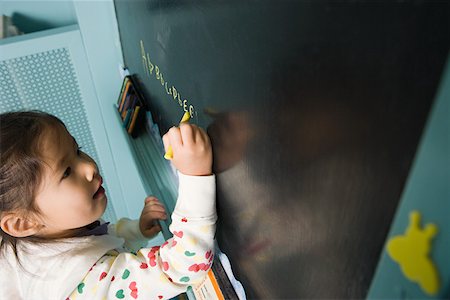 Girl writing on a blackboard Stock Photo - Premium Royalty-Free, Code: 614-02051025