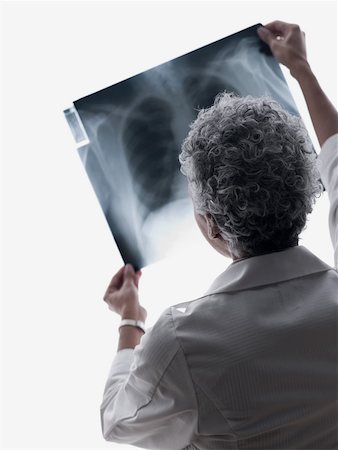 examen de pecho - Doctor looking at an x-ray Foto de stock - Sin royalties Premium, Código: 614-02074407