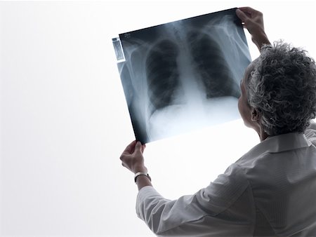 simsearch:614-02984110,k - Doctor looking at an x-ray Fotografie stock - Premium Royalty-Free, Codice: 614-02074437