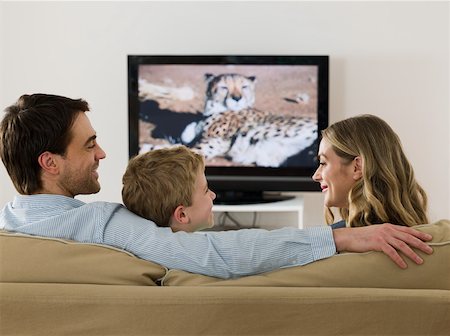 family home tv caucasian - A family watching tv and talking Stock Photo - Premium Royalty-Free, Code: 614-02074916