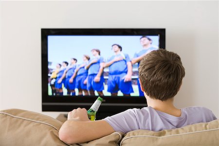 Un jeune homme regardant un match de football Photographie de stock - Premium Libres de Droits, Code: 614-02074923