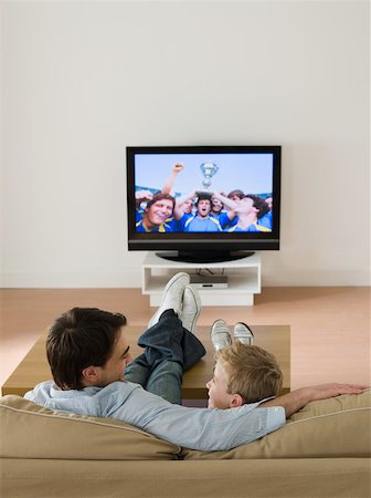 football father and sons - Father and son watching a football match Stock Photo - Premium Royalty-Free, Code: 614-02074939