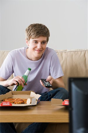 pizza tv - A young man watching tv Stock Photo - Premium Royalty-Free, Code: 614-02074932
