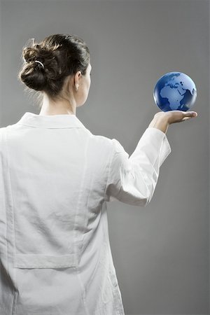 Female scientist holding a globe Stock Photo - Premium Royalty-Free, Code: 614-02073637