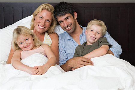 Portrait of a family in bed Stock Photo - Premium Royalty-Free, Code: 614-02073804