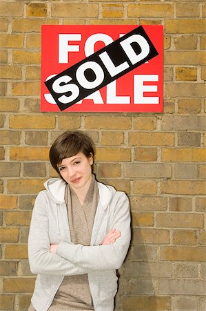sold - Young woman and sold sign Stock Photo - Premium Royalty-Free, Code: 614-02240669