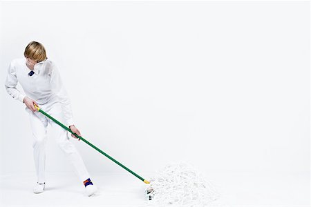 person holding broom - A man sweeping up shredded paper Stock Photo - Premium Royalty-Free, Code: 614-02242414