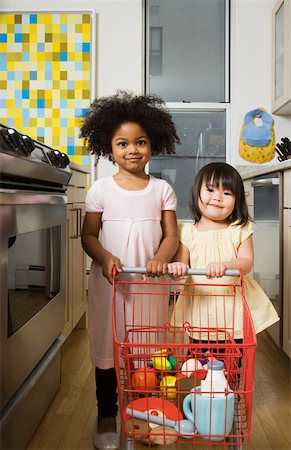 shop to play - Girls pushing a toy shopping trolley Stock Photo - Premium Royalty-Free, Code: 614-02242722