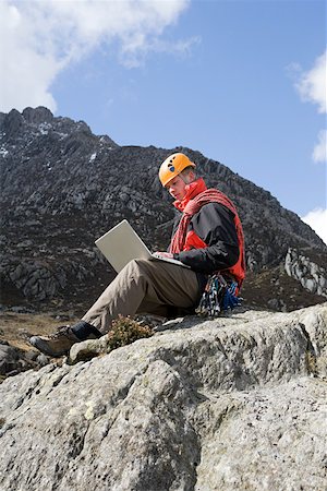 snowdonia national park - A man using a laptop on a rock Stock Photo - Premium Royalty-Free, Code: 614-02243090