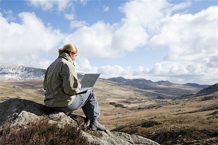 snowdonia - A woman sat on a rock using a laptop Foto de stock - Sin royalties Premium, Código: 614-02243148