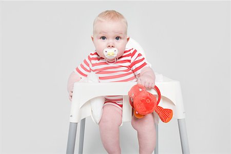 A baby girl in a high chair Foto de stock - Royalty Free Premium, Número: 614-02243168