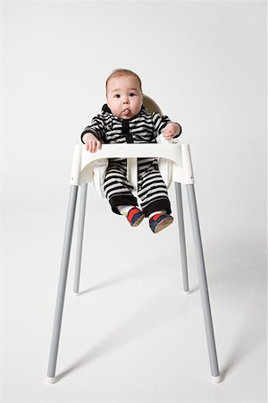 A baby in a high chair Foto de stock - Royalty Free Premium, Número: 614-02243209