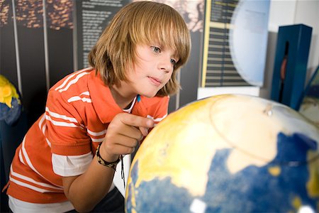 Boy looking at a globe Stock Photo - Premium Royalty-Free, Code: 614-02344414