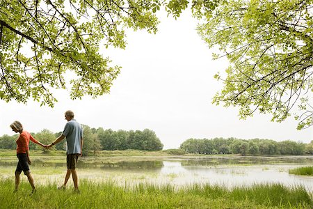 Couple holding hands by lake Stock Photo - Premium Royalty-Free, Code: 614-02394419