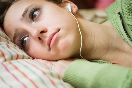 sad person laying down - A teenage girl listening to music Stock Photo - Premium Royalty-Free, Code: 614-02391899