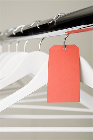 perchero - Red label on a clothes hanger Foto de stock - Sin royalties Premium, Código: 614-02392343