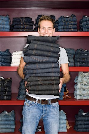 Man holding a stack of jeans Stock Photo - Premium Royalty-Free, Code: 614-02392362