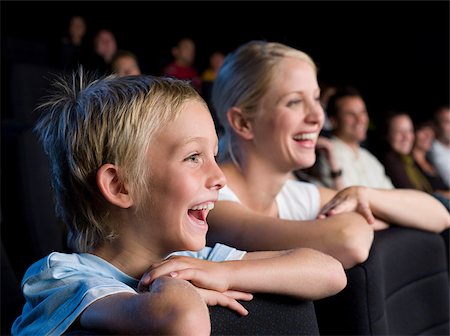 photo of theatre audience laughing - Mother and son watching a movie Stock Photo - Premium Royalty-Free, Code: 614-02392982