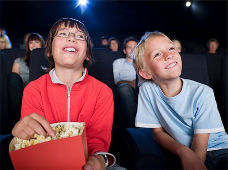 photo of theatre audience laughing - Two boys watching a movie Stock Photo - Premium Royalty-Free, Code: 614-02393010