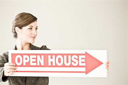 Une femme tenant une affiche de la journée portes ouvertes Photographie de stock - Premium Libres de Droits, Code: 614-02393243