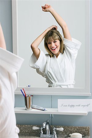 A happy woman looking in a mirror Foto de stock - Sin royalties Premium, Código: 614-02393454