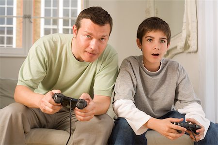 sofa two boys video game - Father and son playing video game Stock Photo - Premium Royalty-Free, Code: 614-02614073