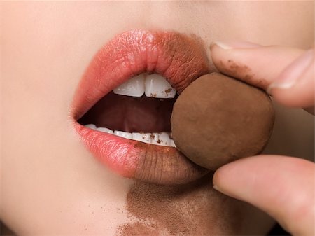 finger in mouth - Woman eating chocolate truffle Stock Photo - Premium Royalty-Free, Code: 614-02613048