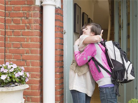 standing at front door - Mother hugging her daughter Stock Photo - Premium Royalty-Free, Code: 614-02639758