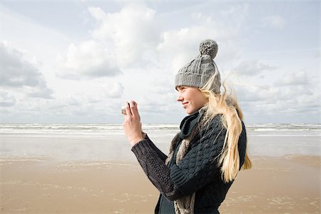 Woman by the sea with camera Stock Photo - Premium Royalty-Free, Code: 614-02640006