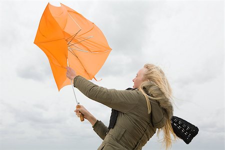 simsearch:614-02680509,k - Woman struggling with umbrella Foto de stock - Royalty Free Premium, Número: 614-02640021