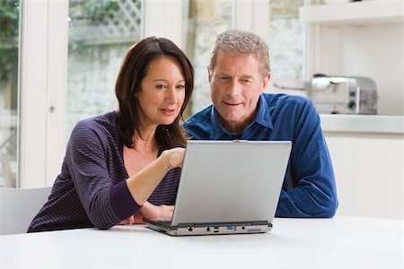 senior couple computer not smiling - A couple using a laptop Stock Photo - Premium Royalty-Free, Code: 614-02640095