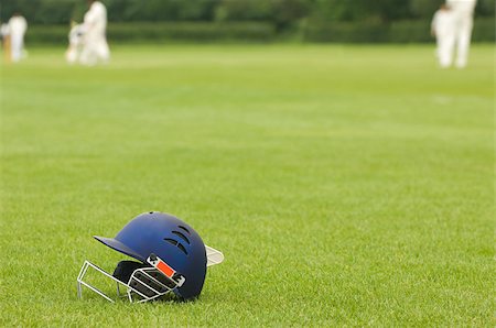 Cricket helmet on a cricket ground Fotografie stock - Premium Royalty-Free, Codice: 614-02640264