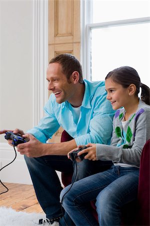 dad daughter computer games - Father and daughter playing video game Stock Photo - Premium Royalty-Free, Code: 614-02640784