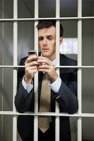 simsearch:614-02739996,k - Businessman in cell with cellphone Foto de stock - Royalty Free Premium, Número: 614-02739996