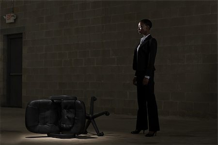 dark suit - Businesswoman and fallen chair Stock Photo - Premium Royalty-Free, Code: 614-02740116