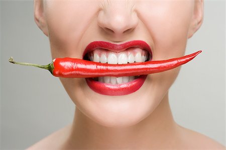 eat mouth closeup - Woman with a red chili pepper between her teeth Stock Photo - Premium Royalty-Free, Code: 614-02740379