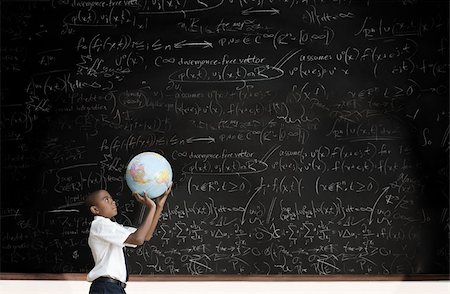 Boy with globe in front of blackboard Stock Photo - Premium Royalty-Free, Code: 614-02762786