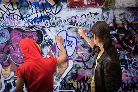 Un jeune homme et une femme graffiti de pulvérisation Photographie de stock - Premium Libres de Droits, Code: 614-02763880