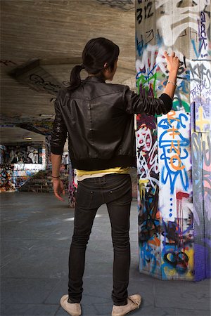 A young man spraying graffiti Fotografie stock - Premium Royalty-Free, Codice: 614-02763894