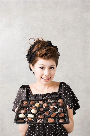 Woman with tray of chocolates Stock Photo - Premium Royalty-Free, Code: 614-02838641