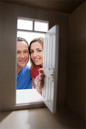 dollhouse - Young couple looking through door of model house Stock Photo - Premium Royalty-Free, Code: 614-02934136